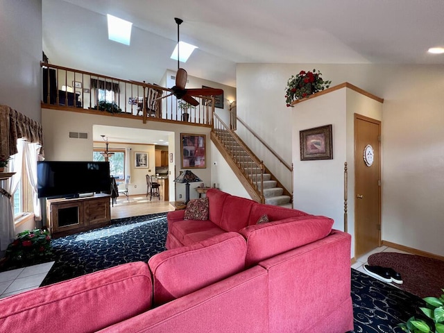 living room with a towering ceiling and ceiling fan