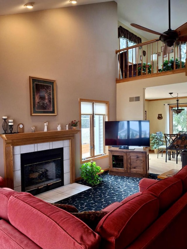 living room with a high ceiling and a tile fireplace