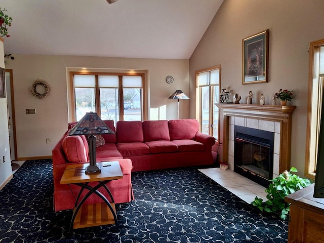 carpeted living room with a tiled fireplace and vaulted ceiling