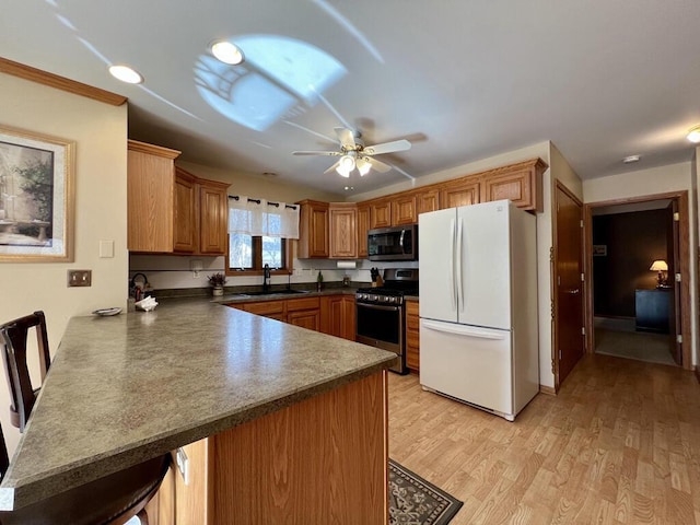 kitchen with appliances with stainless steel finishes, kitchen peninsula, sink, and a breakfast bar area