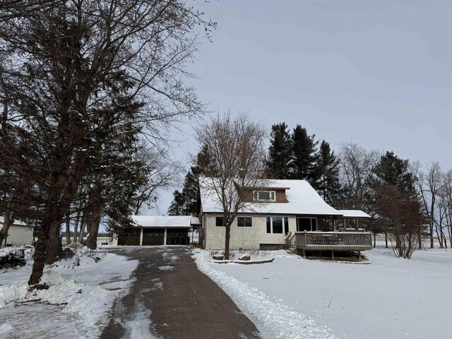 view of front of property featuring a garage, an outdoor structure, and a deck