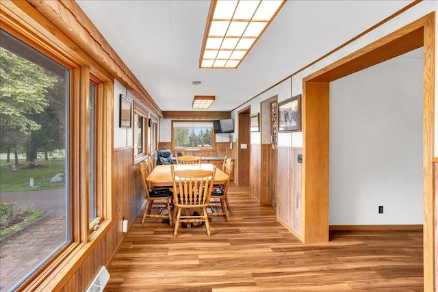 dining room featuring hardwood / wood-style flooring and wood walls