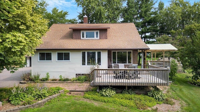 rear view of property with a wooden deck and a yard