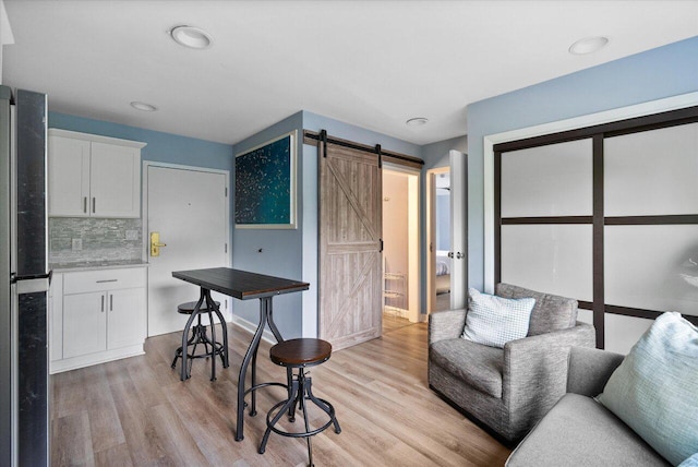 interior space with a barn door and light hardwood / wood-style floors