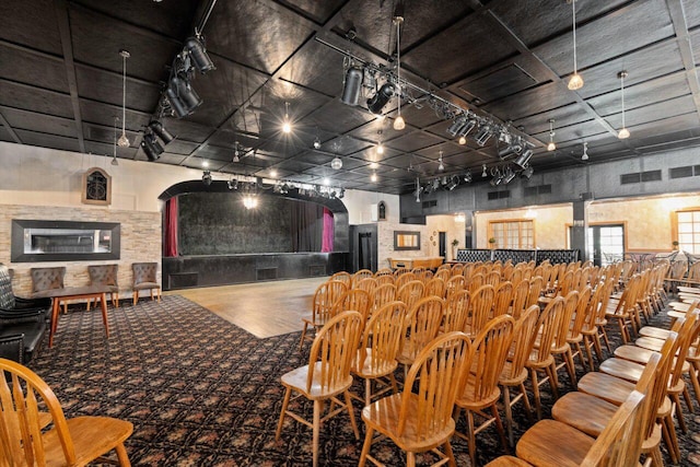 cinema room with hardwood / wood-style floors, rail lighting, and bar area