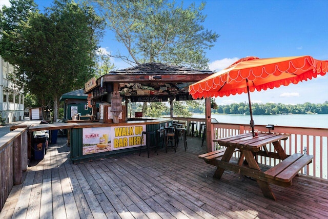 deck with exterior bar, a gazebo, and a water view