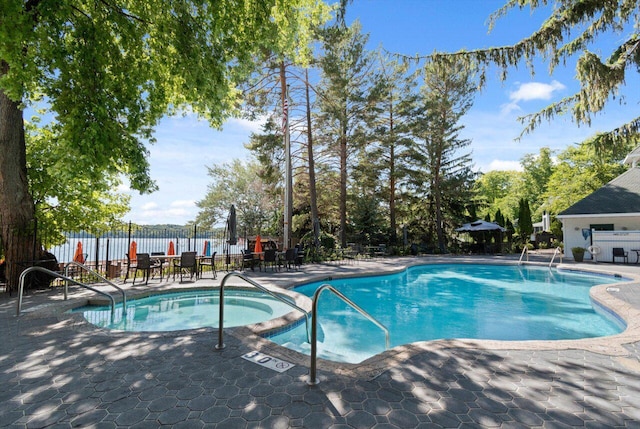 view of swimming pool with a community hot tub and a patio area