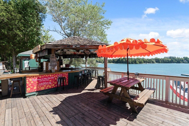 dock area featuring a gazebo, a deck with water view, and an outdoor bar