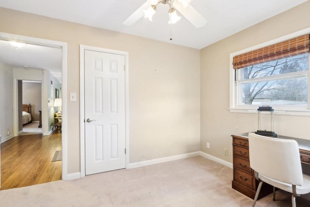 carpeted office featuring ceiling fan