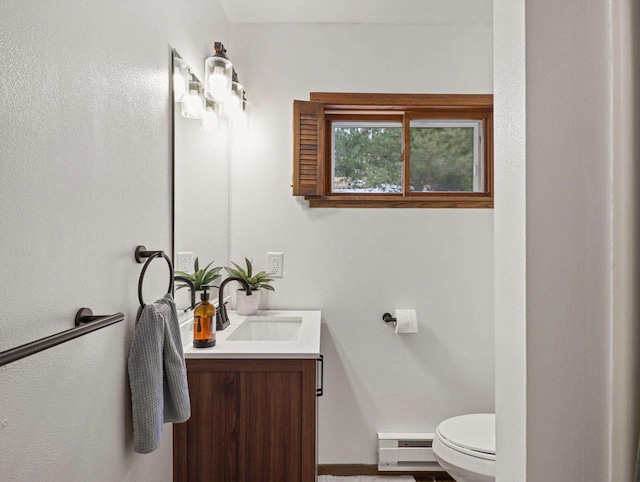 bathroom featuring vanity, baseboard heating, and toilet