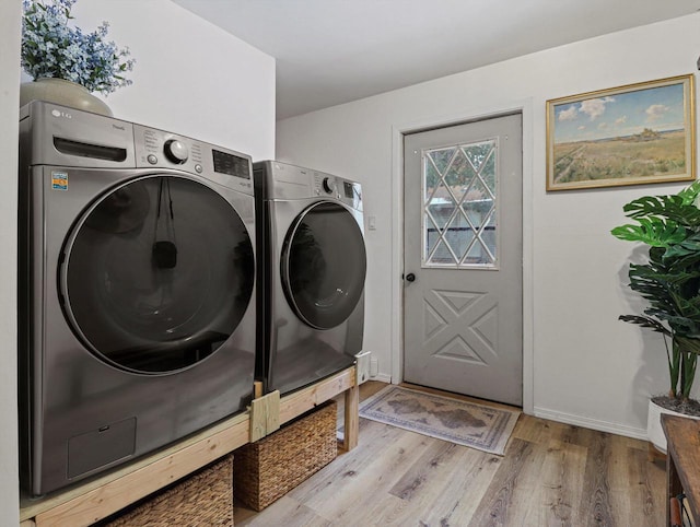 laundry area with light hardwood / wood-style flooring and washer and dryer