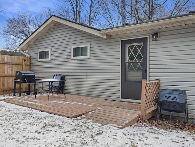 snow covered property entrance with a deck