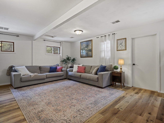 living room with light hardwood / wood-style flooring and beamed ceiling