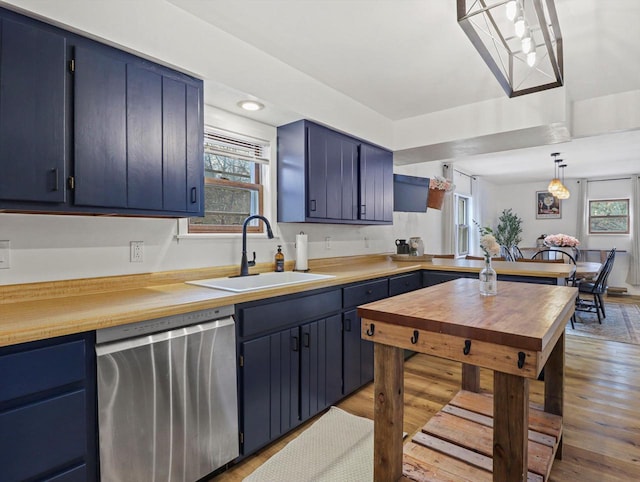 kitchen featuring blue cabinets, dishwasher, sink, and hanging light fixtures