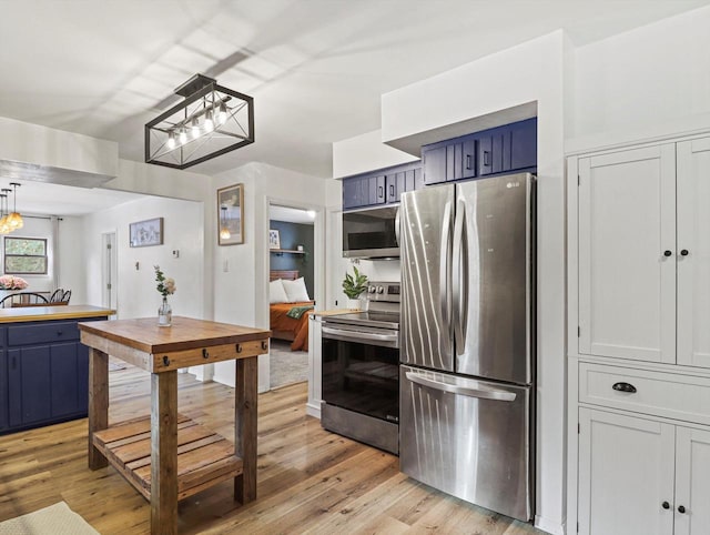 kitchen featuring a notable chandelier, light wood-type flooring, stainless steel appliances, and blue cabinetry