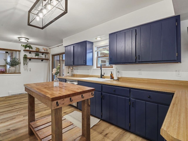 kitchen with sink, light wood-type flooring, and blue cabinets