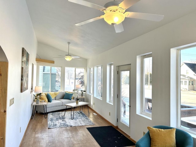 sunroom / solarium featuring ceiling fan, plenty of natural light, and vaulted ceiling