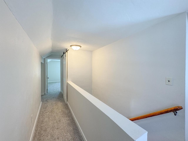 hallway with vaulted ceiling and light carpet