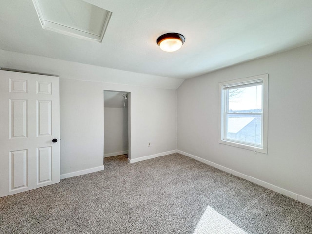 unfurnished bedroom featuring a closet, lofted ceiling, and carpet