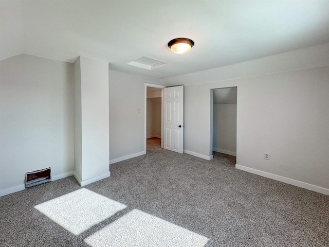 unfurnished bedroom featuring vaulted ceiling, a closet, and carpet flooring