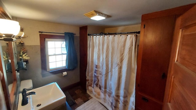 bathroom with hardwood / wood-style flooring, sink, and curtained shower