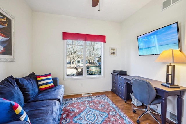 home office with dark wood-type flooring and ceiling fan