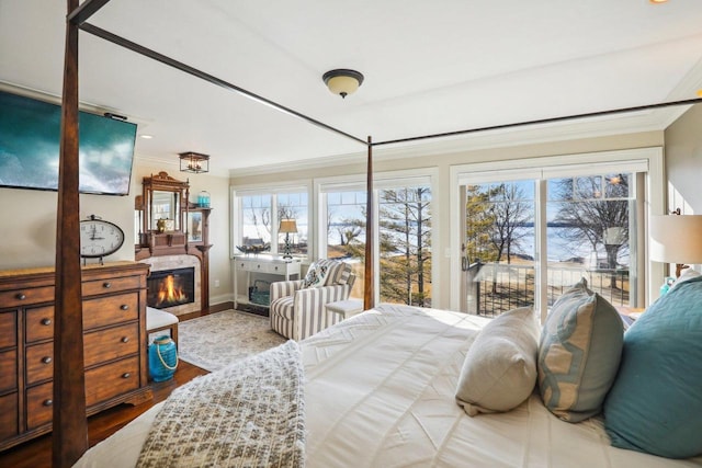 bedroom featuring hardwood / wood-style flooring, ornamental molding, and access to exterior