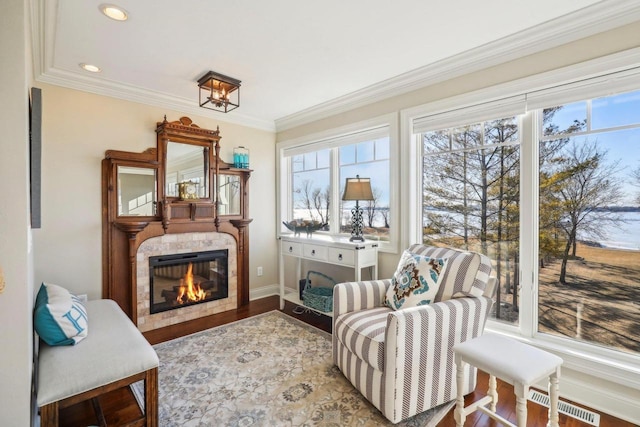 living area with hardwood / wood-style floors and crown molding