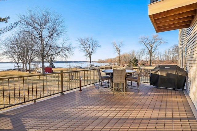 wooden terrace with area for grilling and a water view