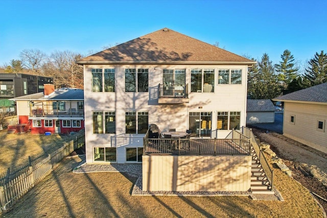 back of property featuring a balcony and a lawn