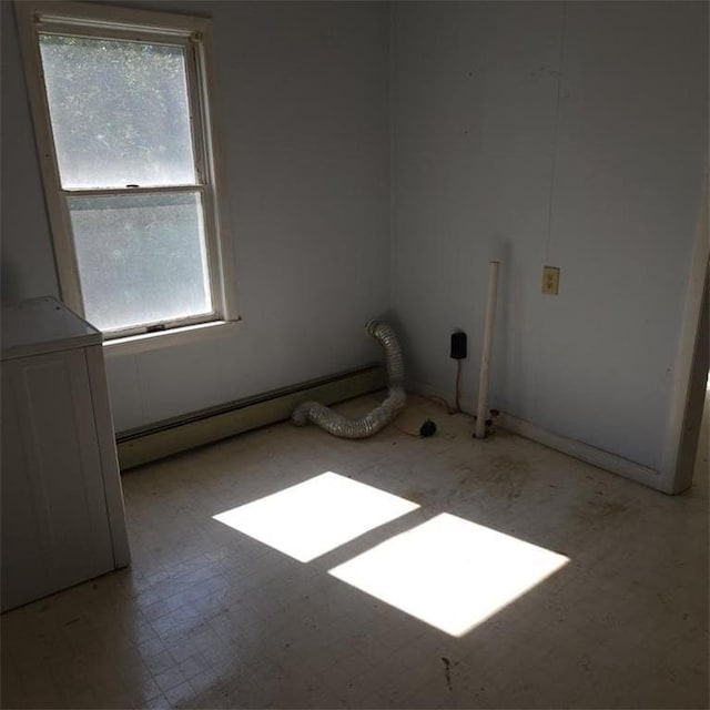 unfurnished room with a baseboard heating unit