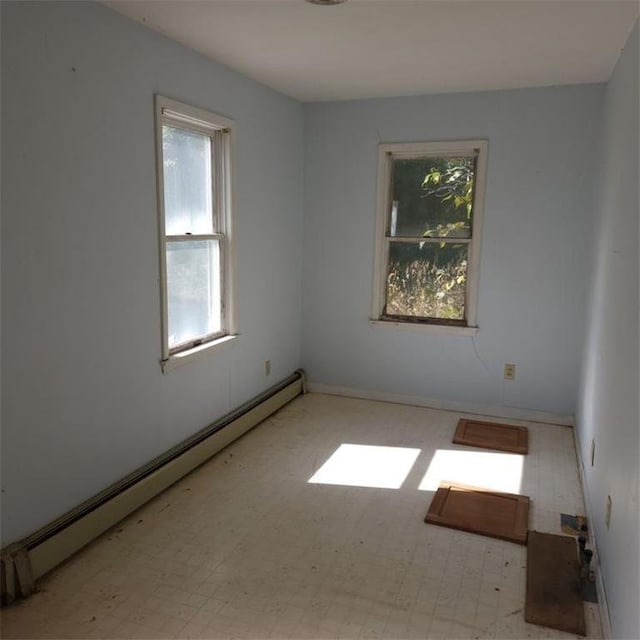 unfurnished room featuring a baseboard heating unit