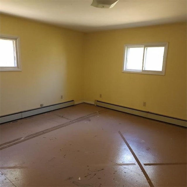 empty room featuring a baseboard radiator and plenty of natural light