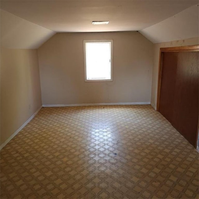 additional living space featuring lofted ceiling