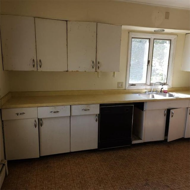 kitchen with black dishwasher, sink, and white cabinets