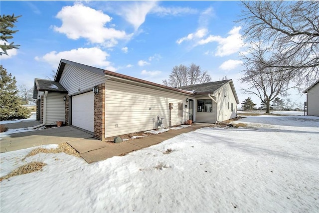 view of snow covered exterior with a garage