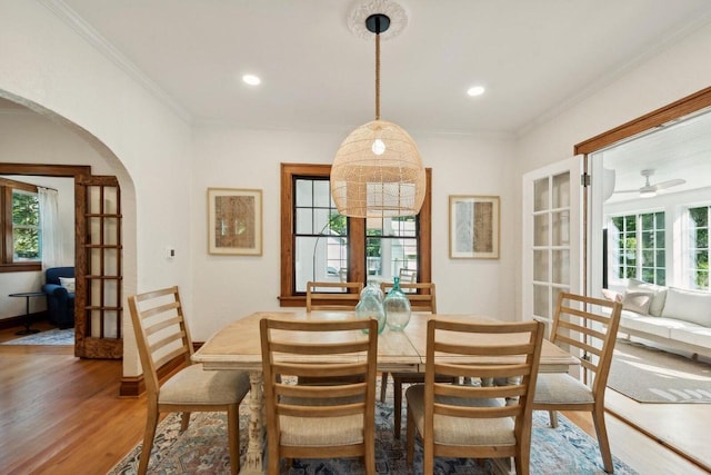 dining space featuring wood-type flooring and ornamental molding