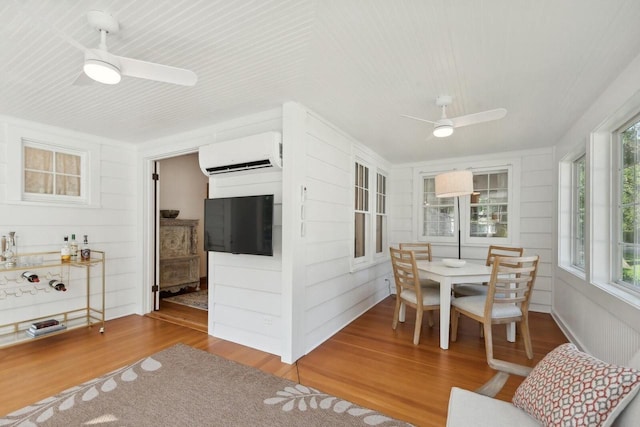 sunroom featuring ceiling fan and a wall unit AC