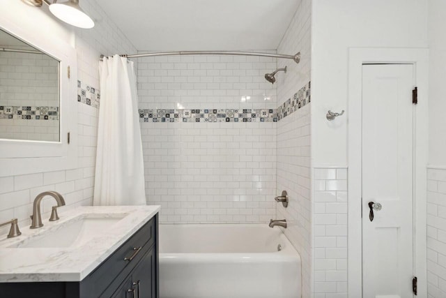 bathroom featuring shower / bath combination with curtain, vanity, and tile walls