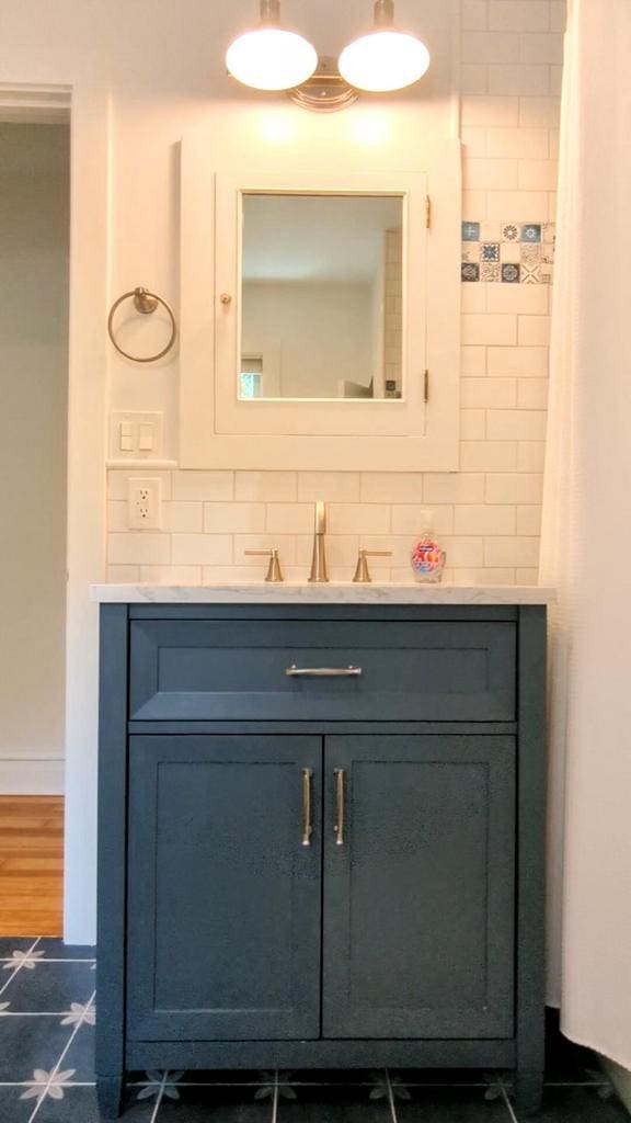 bathroom featuring tasteful backsplash and vanity