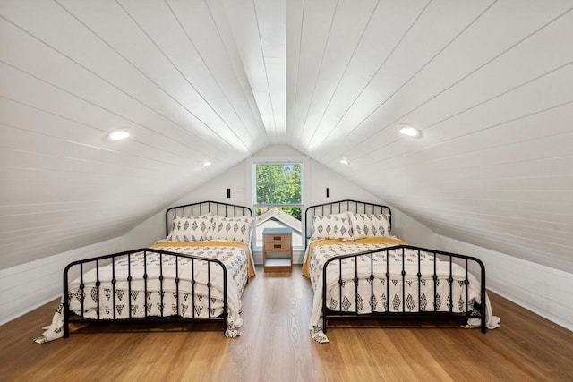 bedroom with wood-type flooring and vaulted ceiling