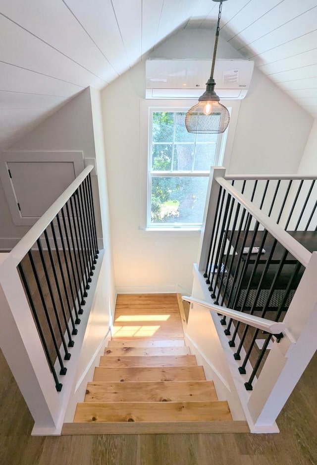 stairway featuring lofted ceiling, hardwood / wood-style floors, and wood ceiling