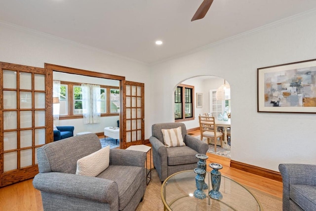 living room featuring crown molding and light hardwood / wood-style flooring