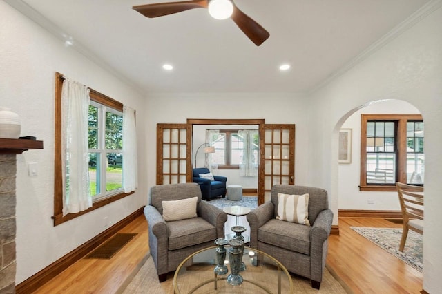 sitting room with crown molding, light hardwood / wood-style flooring, and ceiling fan