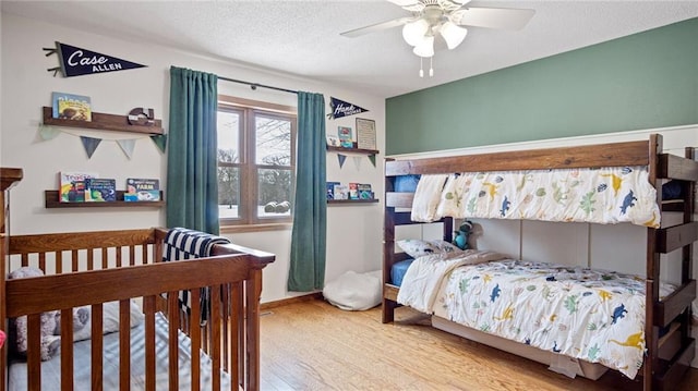 bedroom featuring ceiling fan, light hardwood / wood-style flooring, and a textured ceiling