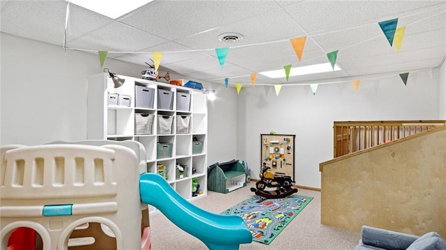 game room with carpet floors and a drop ceiling