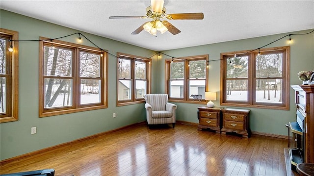 living area featuring hardwood / wood-style flooring and ceiling fan