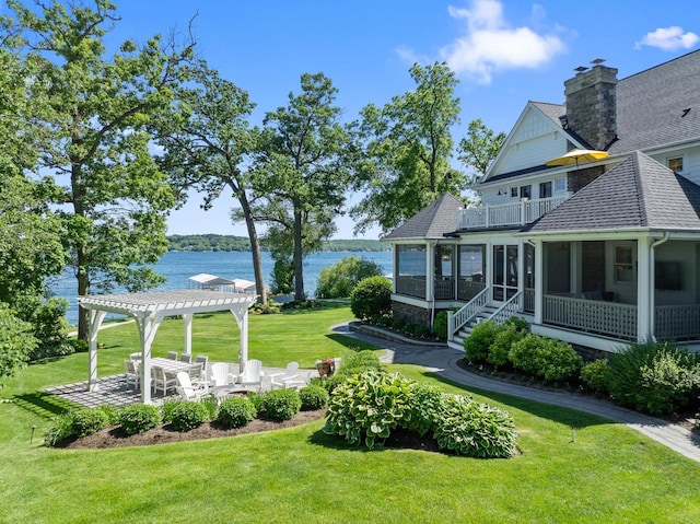 view of yard featuring a balcony, a sunroom, a pergola, a water view, and a patio area