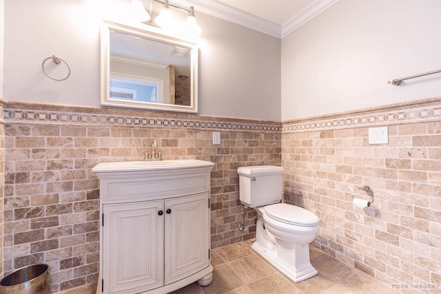 bathroom with tile walls, ornamental molding, vanity, toilet, and tile patterned floors