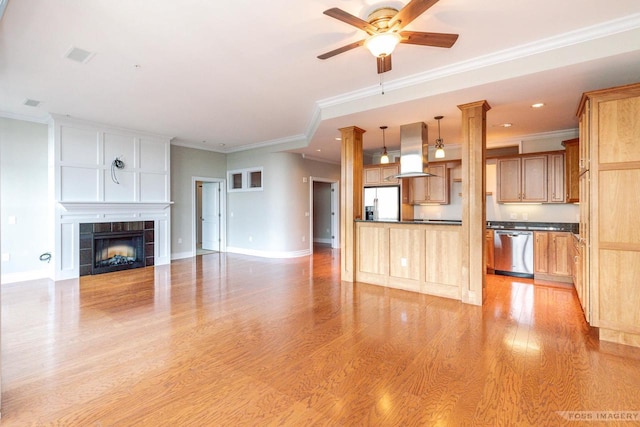 unfurnished living room with crown molding, ceiling fan, a fireplace, and light hardwood / wood-style floors